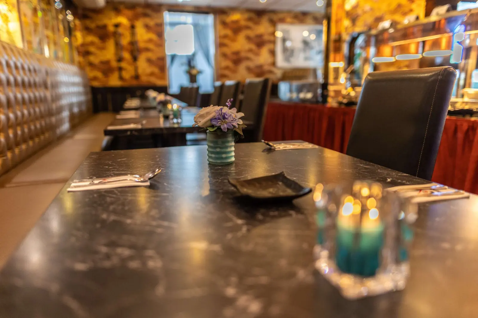 De zaal van Azië: gedekte tafels met theelichtjes en gouden wanden